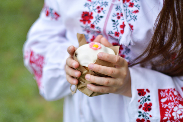 lány egy hagyományos hímzett ing egy virágzó cseresznye kertben.Gyerek hagyományos húsvéti torta a kezében. Kellemes húsvéti napot, keresztény hagyományok.Másoló hely.Puha fókusz - Fotó, kép