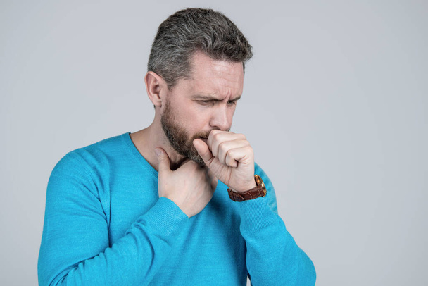 sick man has cough on grey background. mens health. male casual fashion. unshaven guy with bristle and moustache. mature guy with sore throat. copy space. man in casual wear has grizzled hair. - Photo, Image