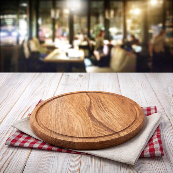 Napkin and pizza board on wooden desk top view mock up. Pizzeria interior. Selective focus. - Fotó, kép