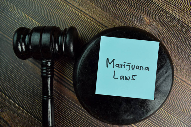 A marihuána törvények ragacsos jegyzetekre írnak, amiket elszigeteltek a fából készült asztalon.. - Fotó, kép