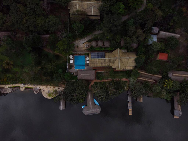 Letecký panorama pohled na Amazon tropický deštný prales exotický svěží džungle eco lodge hotel dřevěná kabina chůdy chata u řeky jezera v Jižní Americe - Fotografie, Obrázek