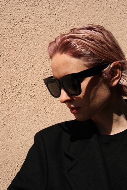 Vertical headshot of young stylish woman with pinkish hair, wearing sunglasses. - Foto, afbeelding