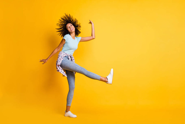 Photo of funny shiny dark skin wavy lady wear blue t-shirt dancing empty space isolated yellow color background - Photo, image