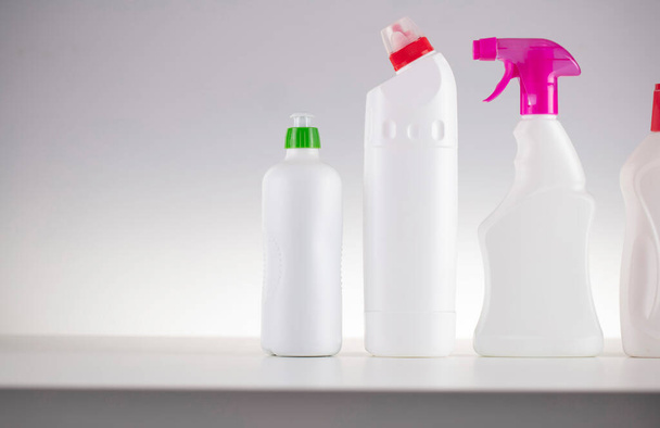 Thema Haus- und Büroreinigung. Set weißer Flaschen mit klingenden Flüssigkeiten auf weißem Hintergrund. - Foto, Bild