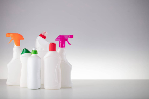 Тема уборки дома и офиса. Набор белых бутылок с клиническими жидкостями на белом фоне. - Фото, изображение