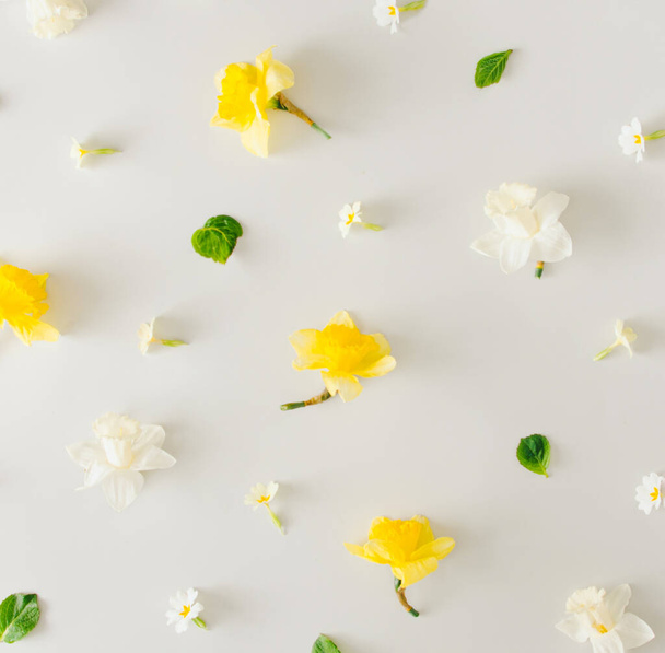 Fondo romántico con flores blancas y amarillas sobre fondo gris pastel. Composición creativa plana laica. - Foto, Imagen