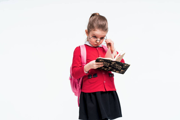 Adorable little girl in red school jacket, black dress, backpack - Photo, Image