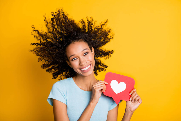 Photo of funky funny dark skin curly girl dressed blue t-shirt wing blowing face holding like card isolated yellow color background - Foto, Imagem