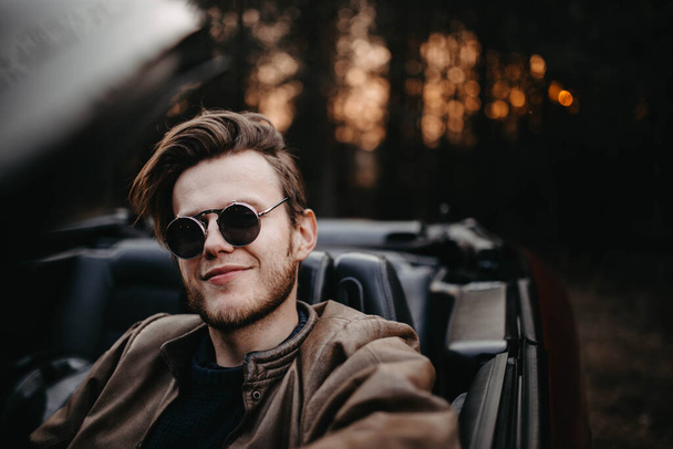 fashionable man in sunglasses in a convertible, pretentious driver. - Photo, Image