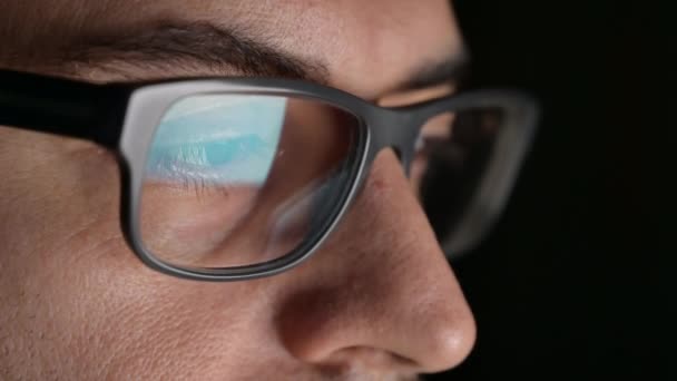 Makro auf dem Auge eines Software-Ingenieurs, der arbeitet: Der Blick richtet sich auf den Bildschirm, auf der Linse der Brille sehen wir die Spiegelung.Klares und kristallklares Bild auf der rechten Linse. Selektiver Fokus - Filmmaterial, Video
