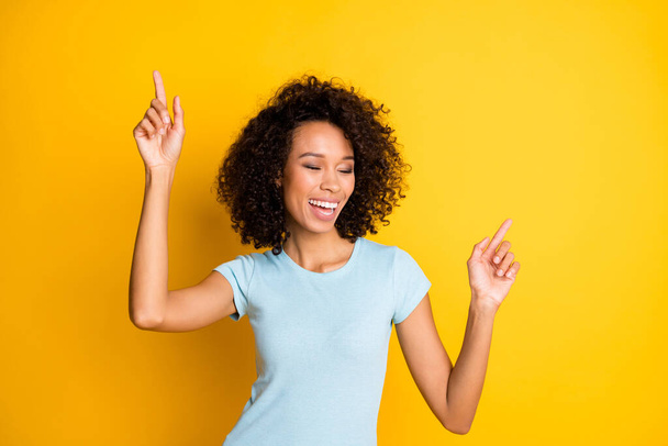 Photo portrait of dancing afro american girl smiling laughing isolated on vivid yellow colored background - Foto, afbeelding