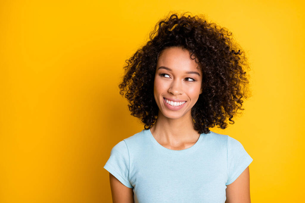 Photo portrait of dreamy afro american woman looking at blank space isolated on vivid yellow colored background - Zdjęcie, obraz