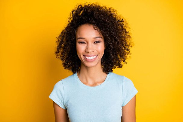 Photo portrait of gorgeous afro american curly girl smiling isolated on vivid yellow colored background - Foto, imagen