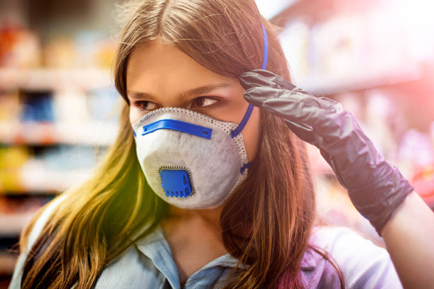 Mädchen trägt geschützte Maske im Geschäft. Einkaufszeit während des Coronavirus-Ausbruchs. Mädchen mit medizinischer Maske. Quarantäne- und Schutzvirus, Grippe, Epidemie COVID-19. Coronavirus-Quarantäne. - Foto, Bild
