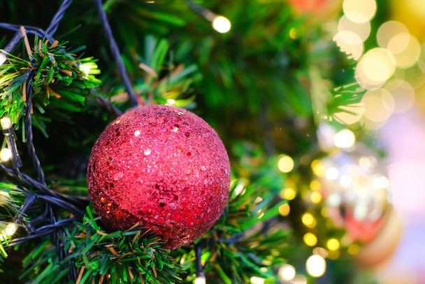 Κόκκινη χριστουγεννιάτικη μπάλα πολυτελείας σε κλαδί πεύκου Χριστουγεννιάτικο φεστιβάλ - Φωτογραφία, εικόνα