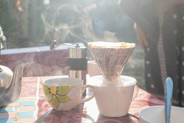 Goteo de café y humo con grupo de personas amigo mano moler café en la luz de la mañana - Foto, Imagen