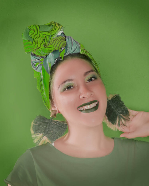 Joven y bella mujer caucasica posa sonriente usando turbante y aretes culturturturales. - Fotoğraf, Görsel
