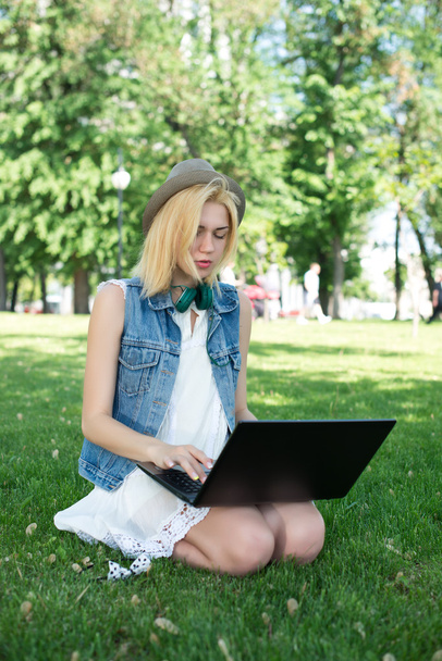 Mixed race college student sitting on the grass working - Photo, image
