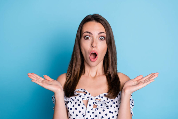 Photo of excited young girl open palms mouth shocked face wear dotted blouse isolated blue color background - Foto, Imagem