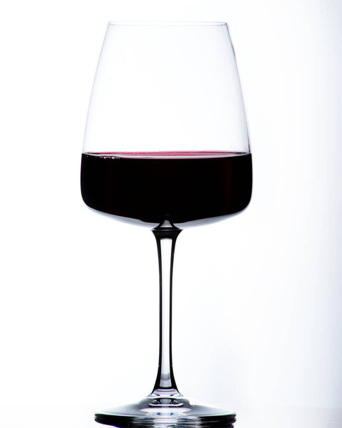 schönes Glas auf weißem Hintergrund mit Rotwein - Foto, Bild