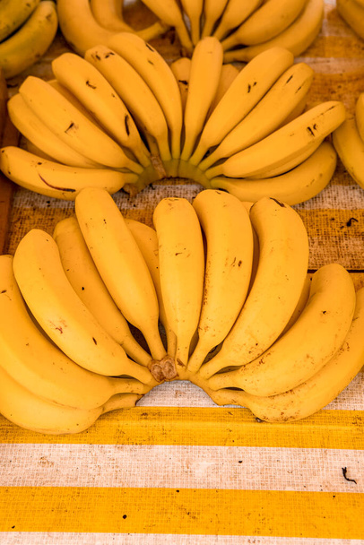 Ripe bananas at the street market in Brazil. Yellow bananas are on the counter. Bunch of bananas on sale at a street stall. - Photo, Image