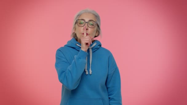 Iäkäs mummo nainen painaa etusormi huulille tekee hiljaisuus ele merkki älä kerro salaista - Materiaali, video
