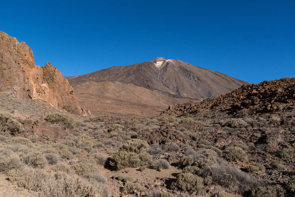 View of the unique rock formation Roques de Garcia with the famous peak of the Pico del Teide volcano in the background at sunrise, Teide National Park, Tenerife, Canary Islands, Spain - Photo, Image
