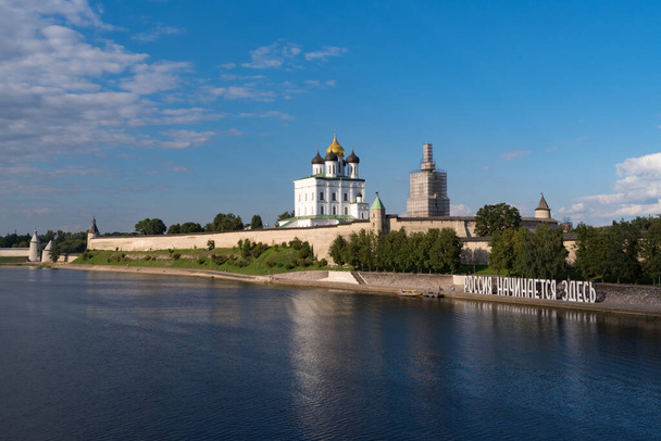 ヴェリカヤ川の岸。インストール"ロシアはここから始まります。朝のプスコフ・クレムリン。ロシアのプスコフにあるトリニティ大聖堂 - 写真・画像