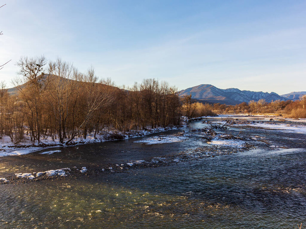 Winter in the foothills, an ice-free river on a frosty morning in the rays of the rising sun. - Fotó, kép