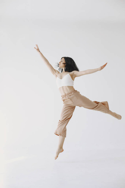 Beautiful young woman dancing in studio - Фото, изображение