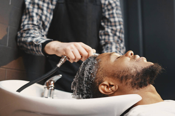 Young African-american man visiting barbershop - Zdjęcie, obraz