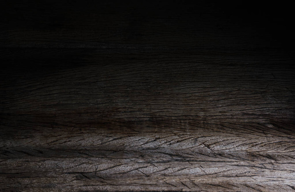 Antigua mesa de madera en cocina o interior, ambiente vintage sobre un fondo oscuro. O negro en una tabla marrón Adecuado para su uso como telón de fondo o pantalla. - Foto, imagen