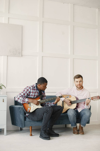 African man and Caucasian man playing guitar - Φωτογραφία, εικόνα