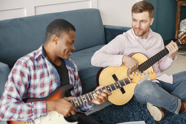 African man and Caucasian man playing guitar - Fotó, kép