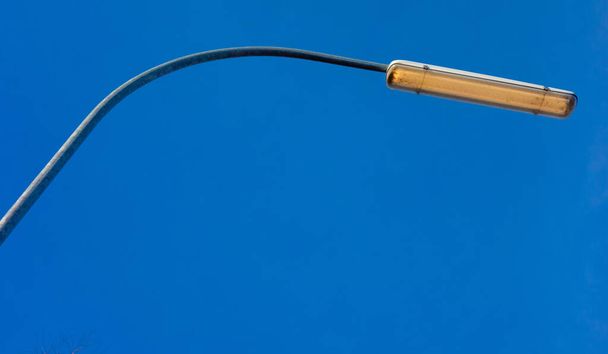A close up shot of a street lamp with blue sky on the background - Zdjęcie, obraz