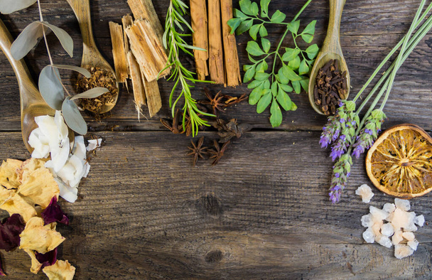variety of flowers, herbs, candles and essences for aromatherapy, on rustic wood - Fotó, kép