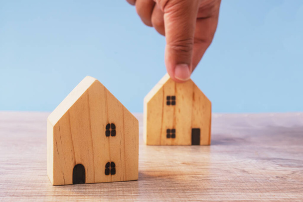 muž ruční držení domu dřevěné modely, investiční pojištění a nákup domů, realitní koncept - Fotografie, Obrázek
