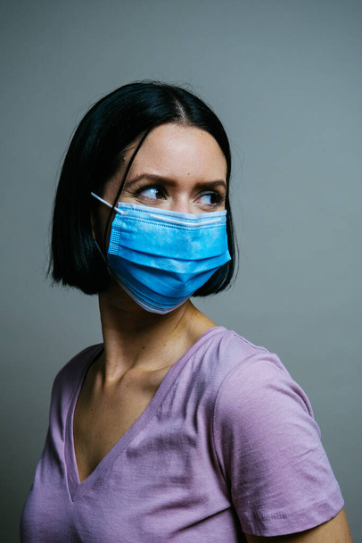 retrato de uma jovem mulher em uma máscara médica e uma face protetora. - Foto, Imagem