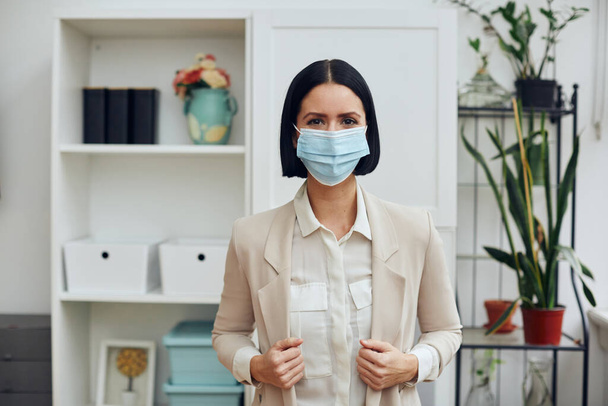 young woman in medical mask and gloves with protective masks in the room - Foto, immagini