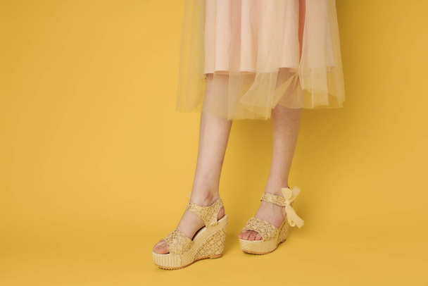 Mujer en vestido piernas zapatos atractivo look amarillo fondo moda - Foto, Imagen