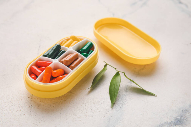 Behälter mit verschiedenen Pillen auf hellem Hintergrund - Foto, Bild