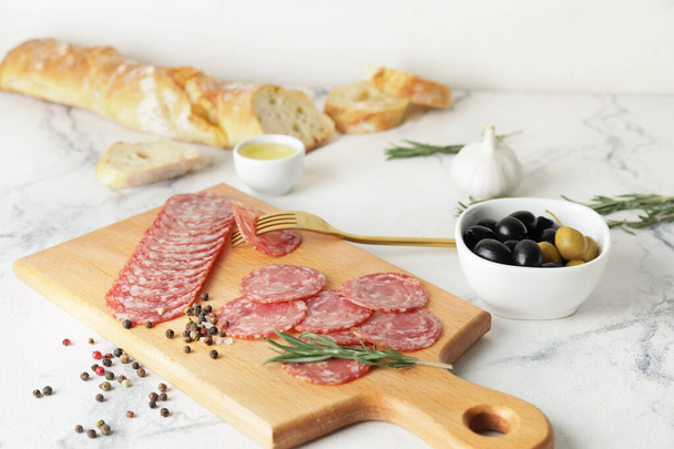 Board with tasty salami on table - Foto, afbeelding