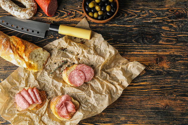 Tasty sandwiches with salami on wooden background - Foto, immagini