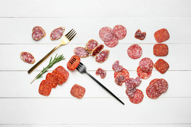 Composition with slices of different sausages on white wooden background - Foto, Imagem