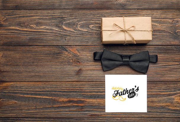 Corbata masculina con tarjeta de felicitación y regalo para el día del Padre sobre fondo de madera - Foto, imagen