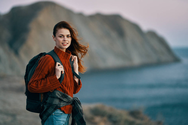 ritratto di una bella donna in montagna vicino al mare e uno zaino sulla schiena. Foto di alta qualità - Foto, immagini