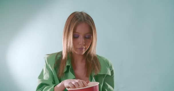 Привлекательная девушка бросает попкорн и пытается поймать их ртом - Кадры, видео