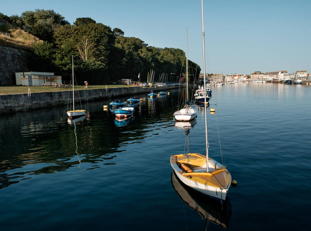 Small boats in Weymouth's harbor in a sunny morning. Yellow boat. Tourism in England. - Photo, Image