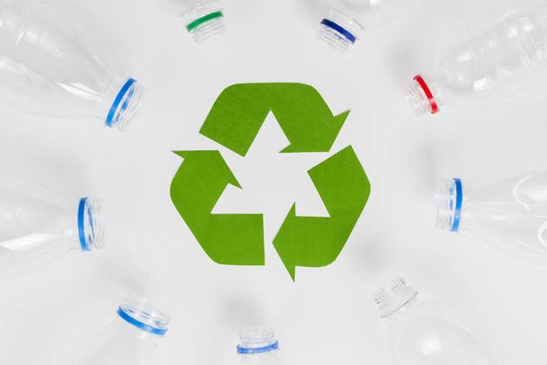 empty plastic bottles around recycling icon. Resolution and high quality beautiful photo - Foto, Imagem