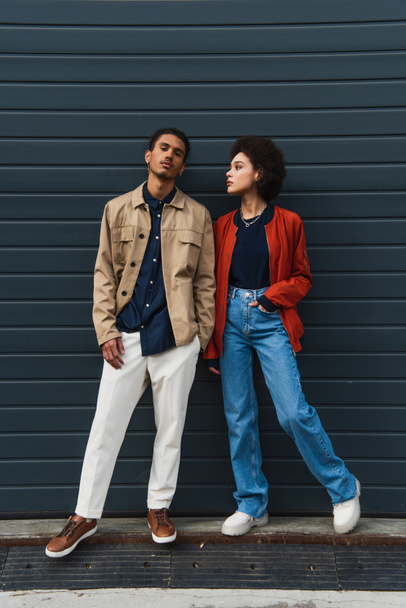 full length of young african american man posing with stylish woman standing with hand in pocket - Photo, Image